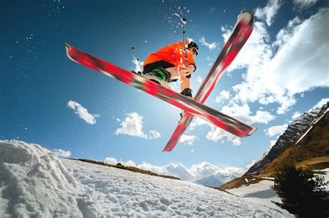 A Young Athlete Skier Does A Trick On A Snow Kicker Jump And Cross Skis