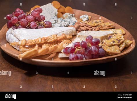 Wooden Cheese Platter With Brie Assorted Cheeses Red Grapes Crackers