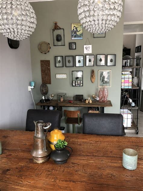 A Wooden Table Topped With Two Chairs Next To A Wall Filled With