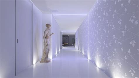 A Long Hallway With White Walls And Flowers On The Wall Along With A