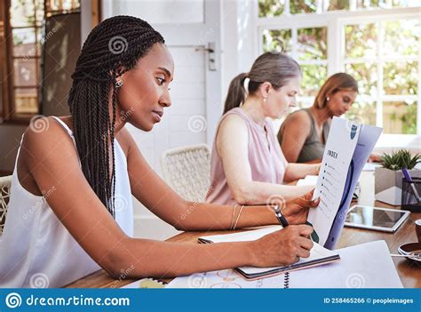 Black Woman With Business Documents Writing At Desk And Women Working Together On Audit Report