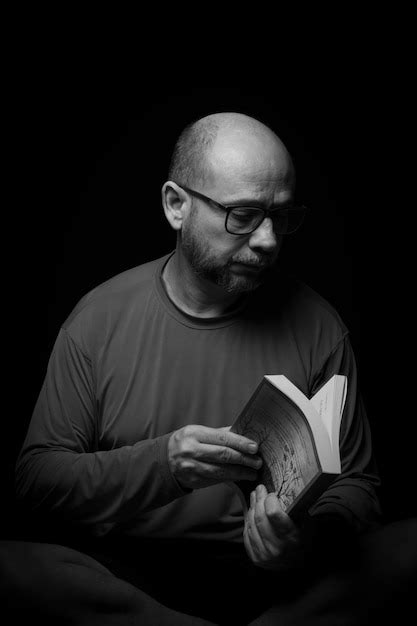 Retrato De Um Homem Barbudo E Careca Lendo Um Livro Contra Fundo Preto