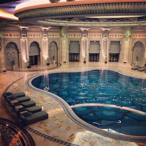 A Large Indoor Swimming Pool In The Middle Of A Room With Stone Floors