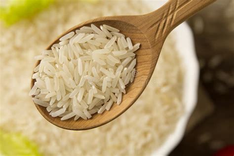 Длинный рис зерна в деревянной ложке на плите предпосылки Здоровая еда ...