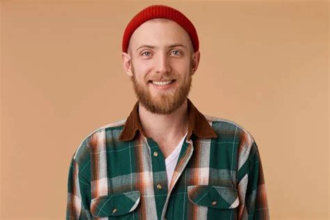 Happy Cheerful Young Man Wearing Red Hat And Shirt Rejoicing At