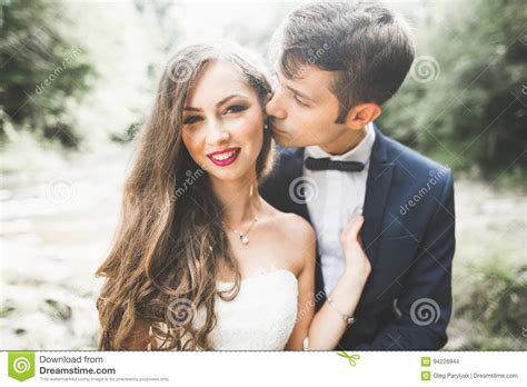 Beautifull Wedding Couple Kissing And Embracing Near The Shore Of A