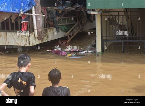 Residents Wade Through A Waterlogged Area In Kampung Melayu East