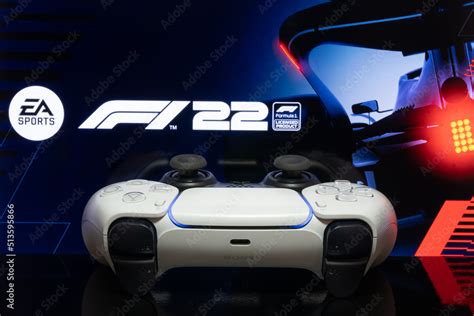 Playstation 5 controller with F1 22 logo at TV screen, selective focus ...