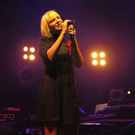 A Woman Singing Into A Microphone On Stage