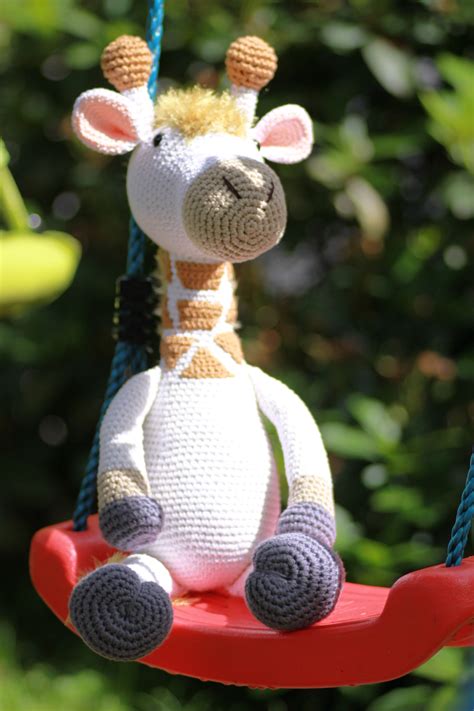 A Stuffed Giraffe Is Sitting On A Swing