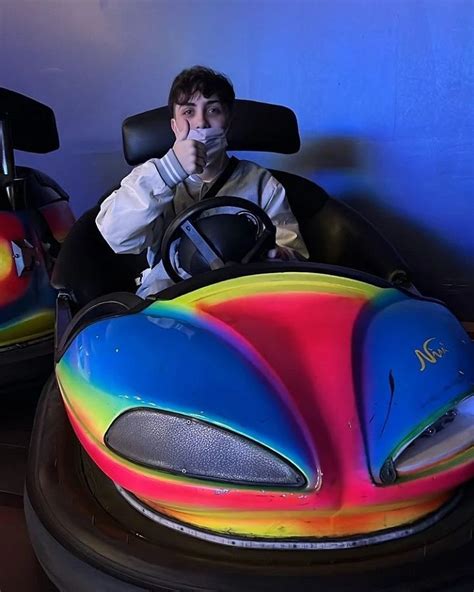 A Man Sitting In A Colorful Bumper Car At An Amusement Park With The