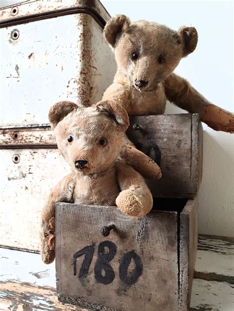 Two Teddy Bears Sitting On Top Of An Old Wooden Box With The Number 789