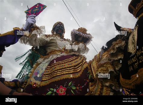 A performer dressed as the Mama Negra walks the streets during the Mama ...