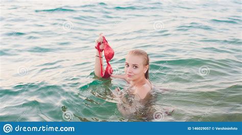 Joven Con El Pelo Largo Rubio Y Topless Sentado En El Agua Y Sosteniendo En La Mano Un Bikini