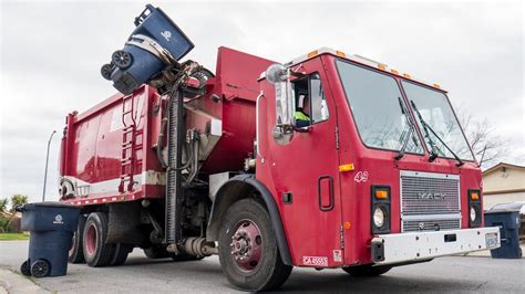 Red Wittke Crocodile Mack LE Side Loader Garbage Truck On Curbside