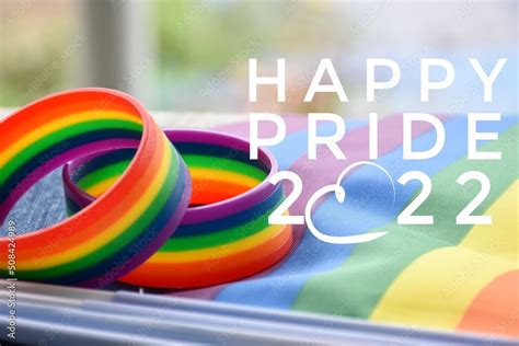 Happy Pride 2022 And Rainbow Wristband Symbol Of Lgbt On Blurred Rainbow Flags Background