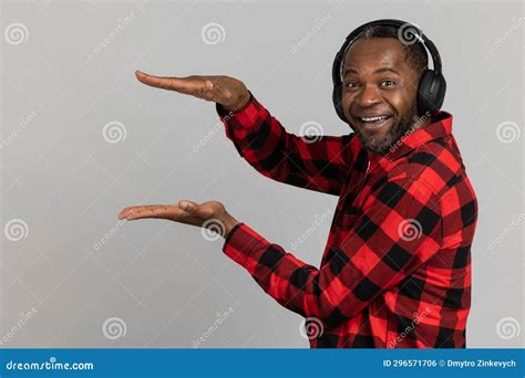 Cheerful Black Bearded Man In Headphones Wearing Red Checkered Shirt