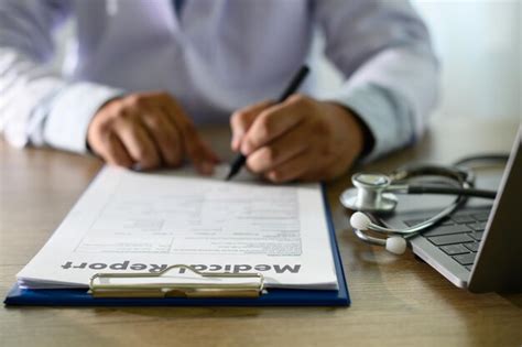 Premium Photo Midsection Of Doctor Writing In Report On Table