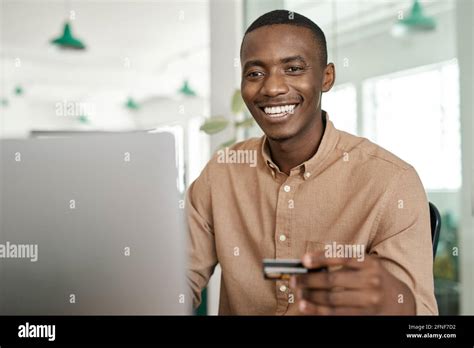 Smiling African Businessman Online Shopping At His Office Desk Stock