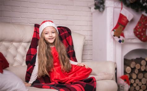 Belle Fille Dans Le Chapeau De Santa Se Trouvant Sur Le Plancher Tir