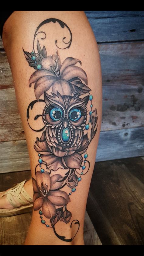 A Womans Leg With An Owl And Flower Tattoo Design On The Side Of Her Thigh