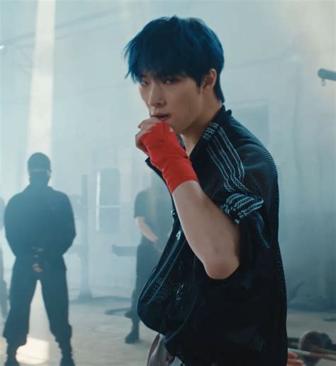 A Man With Blue Hair Wearing Red Boxing Gloves And Standing In Front Of