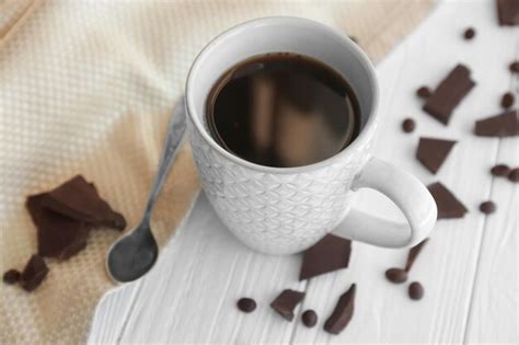 Premium Photo Cup Of Coffee With Chocolate Pieces On Table