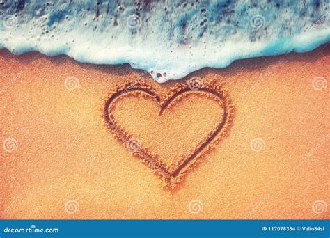 Love Heart On A Sand Of Beach With Wave On Background Stock Photo