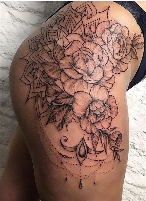 The Back Of A Woman S Thigh With Flowers And An Arrow Tattoo On It