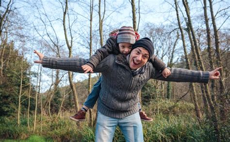 Retrato De Un Padre Feliz Dando Un Paseo A Su Hija En El Bosque Foto