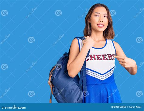 Young Beautiful Chinese Girl Wearing Cheerleader Uniform Holding