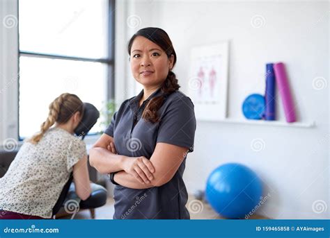 Portrait Of A Chinese Woman Massage Therapist Giving A Neck And Back