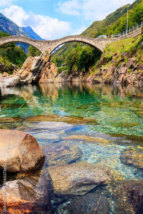 Ancient double arch stone Roman bridge (Ponte dei Salti) over the clear ...