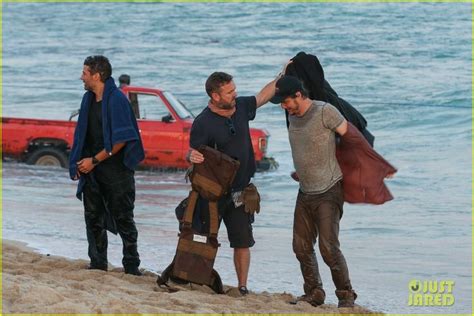 three men are standing on the beach with their surfboards and one man ...