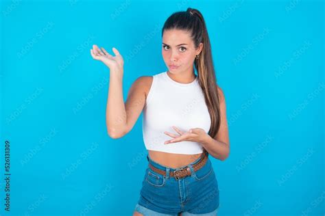 Beautiful Brunette Woman Wearing White Tank Top Over Blue Background