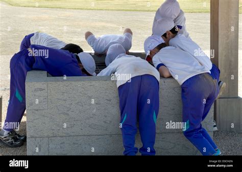 Group Of Curious Young Japanese School Boys In Sports Uniforms Bend