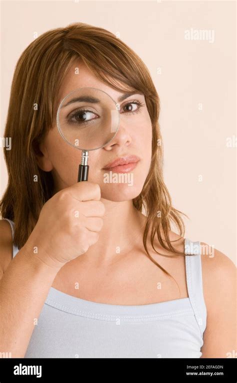 Portrait Of A Young Woman Looking Through A Magnifying Glass Stock