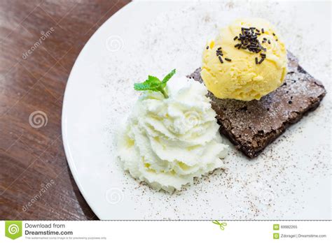 Brownie Del Chocolate Con Helado De La Vainilla En El Plato Imagen De