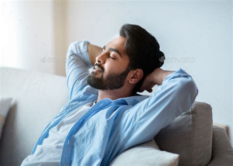 Relax Time Handsome Arab Man Leaning Back On Couch With Closed Eyes