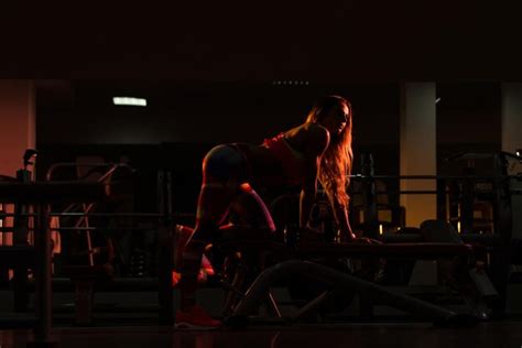 Mujer De Silueta Haciendo Ejercicio Con Pesas En El Gimnasio Y