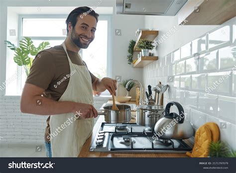 Cheerful Young Man Cooking Something On Stock Photo 2171797079