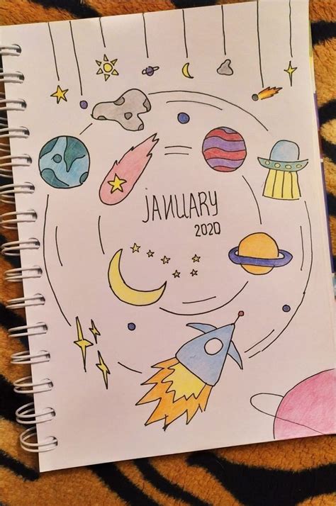 A Spiral Notebook With An Image Of Planets And Stars On It Sitting On