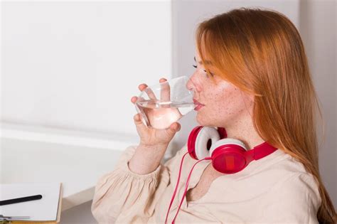 Free Photo | Side view of female teacher drinking water during online class