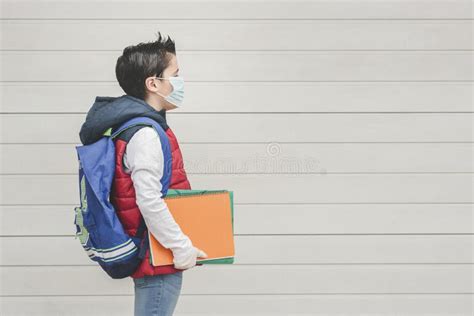 Criança Máscara Médica E Mochila Indo Para a Escola Foto de Stock