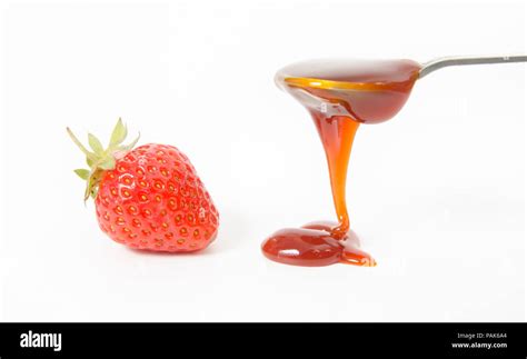 Strawberry Jam Suggested By A Spoon Filled With Red Sauce And Dripping Or Pouring On The White