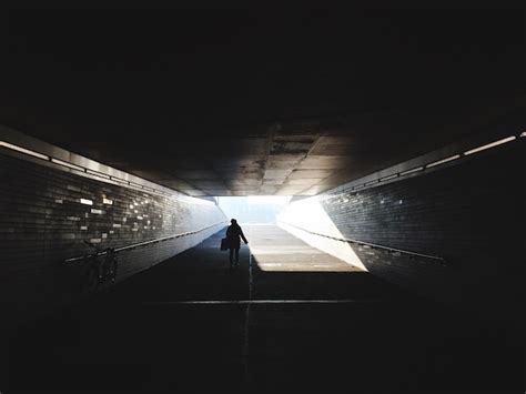 Premium Photo Rear View Of Silhouette Man Walking In Tunnel