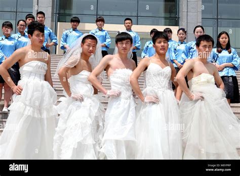 Male Students Wearing Bridal Wedding Dresses Pose For Their Graduation