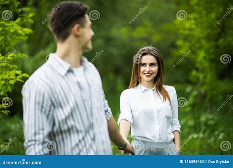 Portrait Of A Happy Couple Walking Together Outdoors In Green Park