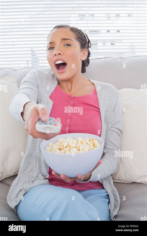 Astonished Attractive Woman Eating Popcorn While Watching Tv Stock