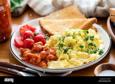 Scrambled eggs, toasted bread and baked beans on a plate. Healthy ...